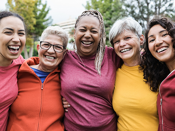 Photo of five women with their arms around each other