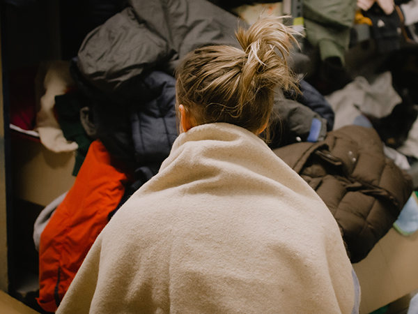 Photo of woman wrapped in a blanket with her back to camera